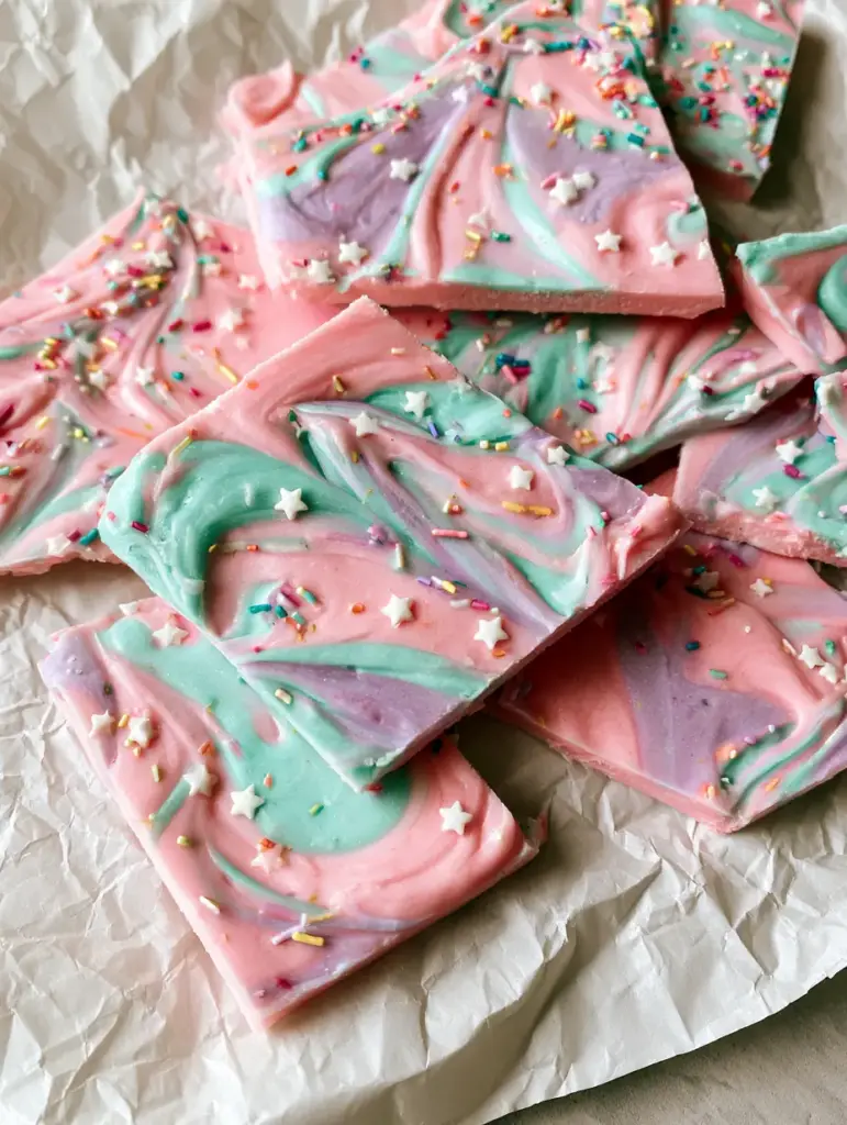 Detailaufnahme der eisigen Textur der Einhorn-Joghurt-Bark mit essbaren Sternen.